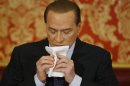 Italy's former Prime Minister Silvio Berlusconi wipes his face during a news conference at Villa Gernetto in Gerno