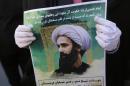 An Iranian woman holds a portrait of Nimr al-Nimr during a demonstration in Tehran on January 3, 2016 against his execution