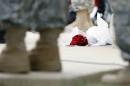 Roses left for shooting victims are seen at the feet of Lt. Gen. Mark Milley, U.S. Sen. John Cornyn, and other military during a news conference near Fort Hood's main gate, Thursday, April 3, 2014, in Fort Hood, Texas. A soldier opened fire Wednesday on fellow service members at the Fort Hood military base, killing three people and wounding 16 before committing suicide. (AP Photo/Eric Gay)