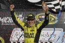 Matt Kenseth raises his arms in victory lane after winning the NASCAR Sprint Cup series auto race at Michigan International Speedway, Sunday, Aug. 16, 2015, in Brooklyn, Mich. (AP Photo/Carlos Osorio)