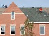 Builders work at roof of new housing construction site in Alexandria