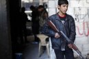 A young Free Syria Army fighter holds his gun during a clash with Syria forces loyal to President Bashar al Assad at the front line in Aleppo