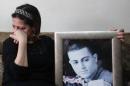 The mother of Arab-Israeli Mohammed Musallam holds a portrait of her son at their home in the east Jerusalem on March 11, 2015, after the Islamic State (IS) released a video purportedly showing a young boy executing her son