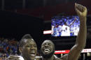 Florida's forward Will Yeguete (15) Patric Young (4) celebrate after the second half of an NCAA college basketball game against Kentucky in the Championship round of the Southeastern Conference men's tournament, Sunday, March 16, 2014, in Atlanta. Florida won 61-60. (AP Photo/Steve Helber)