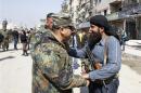 File photo of a member of Syria's armed opposition forces chating with an officer from the forces loyal to Syria's President Assad in Babila town, southeast Damascus, after a local ceasefire agreement was reached