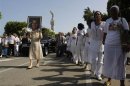 Members of the 'Ladies in White' opposition group march beside the funeral procession of Oswaldo Paya, one of Cuba's best-known dissidents, in Havana