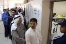 Kuwaiti citizens wait in line to cast their vote at a polling station in Rumaithiya, Kuwait on Saturday, Dec. 1st, 2012. The general election to appoint a new Parliament is the fifth since mid-2006, and the second this year.(AP Photo/Gustavo Ferrari)