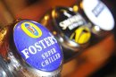 A Foster's logo is seen on a beer pump at an Australian themed bar in west London