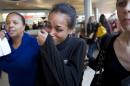 Courtney, center, a friend of one of the victims in Saturday's shooting at the Mall in Columbia, Md,, cries as she walks through the food court with friends after the mall was reopened to the public on Monday Jan. 27, 2014. Three people died Saturday in a shooting at a mall in suburban Baltimore, including the presumed gunman. (AP Photo/Jose Luis Magana)