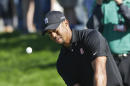 Tiger chips to the second green on the South Course at Torrey Pines where he bogeyed during the third round of the Farmers Insurance Open golf tournament Saturday, Jan. 25, 2014, in San Diego. (AP Photo/Lenny Ignelzi)