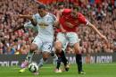 Manchester United's English defender Phil Jones (R) vies with Swansea City's Ecuadorian midfielder Jefferson Montero during the English Premier League match at Old Trafford in Manchester, north-west England on August 16, 2014