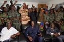 A delegation of mutinous soldiers stand behind Ivory Coast's defence minister Alain-Richard Donwahi (C-front) speaking to journalists after negotiations, on January 7, 2017 in Bouake