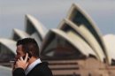 An office worker smokes a cigarette in front of the Sydney Opera House