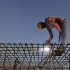 A worker welds iron rods at the construction site of a commercial complex in Ahmedabad