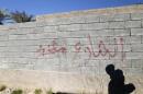 Graffiti warning on a wall saying that the street is mined is seen in the city of Ramadi