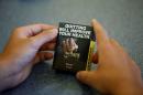 A high school student looks at a mock up of plain cigarette packaging in Ottawa