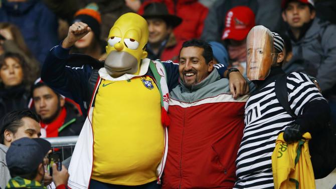 Brazilian fans, including one wearing a Homer Simpson mask and one with a mask of FIFA President Blatter cheer ahead of their team&#39;s first round Copa America 2015 soccer match against Peru at Estadio Municipal Bicentenario German Becker in Temuco