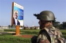 A French soldier stands in front of a poster of ousted President Bozize outside M'poko international airport in Bangui