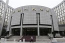 A staff member walks in front of the headquarters of the People's Bank of China, the central bank, in Beijing