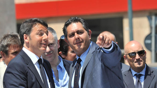 In this picture taken on June 6, 2015 and made available on Sunday, June 7, 2015, Italian premier Matteo Renzi, left, shares a word with Liguria Governor Giovanni Toti, center, in Genoa, Italy. Giovanni Toti, elected just last week, was among the northern Italian politicians vowing to refuse to host any more migrants while asylum requests are being evaluated. (Paolo Zeggio/ANSA via AP)