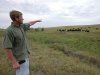 In this photo from Aug. 1, 2012, Todd Eggerling, of Martell, Neb., points to some of his cattle grazing on thin pasture. Due to the summer's record drought and heat his cattle operation is in bad shape. Eggerling would normally graze his 100 head of cattle through September, but the drought has left his pastureland barren. He's begun using hay he had planned to set aside for next year's cattle, and is facing the reality that he will have to sell the cattle for slaughter early at a loss. (AP Photo/Nati Harnik)
