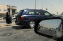 A Saudi woman walks past vehicles stopping at a traffic light in Riyadh, on September 22, 2013
