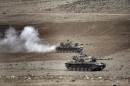 Turkish tanks roll to take positions along the Turkey-Syria border near Suruc, Turkey, Monday, Sept. 29, 2014. U.S.-led coalition air raids targeted towns and villages in northern and eastern Syria controlled by the Islamic State group, including one strike that hit a grain silo and reportedly killed civilians, activists said Monday.(AP Photo/Burhan Ozbilici)
