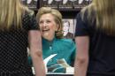 Former U.S. Secretary of State Hillary Clinton smiles as she signs copies of her book "Hard Choices" at a Costco store in Arlington, Virginia