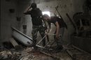 Free Syrian Army fighters inspect damaged items in a house in Aleppo