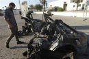 A military personnel examines a car, which exploded near a women's police academy, in Tripoli