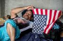 A Cuban resting in a shelter in the town of La Cru , Guanacaste, Costa Rica holds a US flag, on November 17, 2015