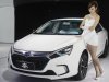 A model stands next to China's BYD QIN at Auto China 2012 in Beijing