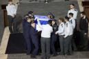Israeli honour guards carry the coffin of former prime minister Ariel Sharon in to the Knesset (the Israeli Parliament) in Jerusalem at the end of the day on January 12, 2014