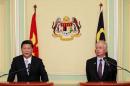 Xi Jinping speaks next to Najib Razak during a joint news conference at Najib's office in Putrajaya