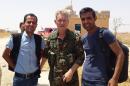 In this handout photo provided by Kurdish journalist Mohammed Hassan, taken on May 19, 2015, Michael Enright, center, a British actor who has had minor roles in Hollywood films, wears the Kurdish fighters military uniform after he joined them battling against the Islamic State group, near Tel Tamr town, northeast Syria. Enright, who played a deckhand in 