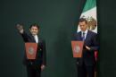 Virgilio Andrade Martinez, left, is sworn-in as the Secretary of Public Administration by Mexican President Enrique Pena Nieto, during a press conference in Mexico City, Tuesday, Feb. 3, 2015. Pena Nieto said Tuesday he has asked the Public Administration Department to investigate the purchases of luxury homes, by himself, his wife and his finance secretary, from government contractors. (AP Photo/Rebecca Blackwell)