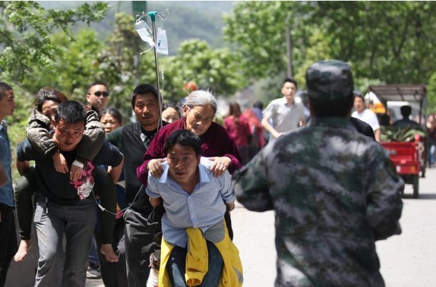 Residents help carry injured people to hospital after the earthquake in southwest China on April 20, 2013