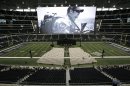 A photo of Christopher Kyle is displayed on the large screen before the start of a memorial service for the former Navy SEAL at Cowboys Stadium, Monday, Feb. 11, 2013, in Arlington, Texas. Thousands are expected to attend the public memorial service for Kyle, the former Navy SEAL sniper who was shot to death at a Texas shooting range. (AP Photo/Brandon Wade)