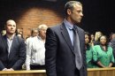 Olympian Oscar Pistorius, foreground, stands following his bail hearing, as his brother Carl, left, and father Henke, second from left, look on in Pretoria, South Africa, Tuesday, Feb. 19, 2013. Pistorius fired into the door of a small bathroom where his girlfriend was cowering after a shouting match on Valentine's Day, hitting her three times, a South African prosecutor said Tuesday as he charged the sports icon with premeditated murder. The magistrate ruled that Pistorius faces the harshest bail requirements available in South African law. (AP Photo)