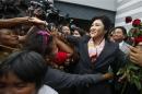 Thailand's Prime Minister Yingluck Shinawatra greets her supporters as she leaves the Permanent Secretary of Defence office in Bangkok