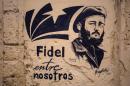 A stencil graffiti featuring Fidel Castro's image says in Spanish "Fidel among us," in an alleyway in Havana, Cuba, Sunday, Nov. 27, 2016. Castro, who led a rebel army to improbable victory in Cuba, embraced Soviet-style communism and defied the power of U.S. presidents during his half century rule, died at age 90 on Friday night. (AP Photo/Desmond Boylan)