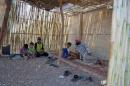Abu Ahmad rests with his children in a temporary summer room he built within a refugee camp that was formerly the summer camp for school children in Zeyzoun