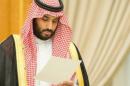 Saudi Arabia's Deputy Crown Prince Mohammed bin Salman looks at a document as Saudi Arabia's cabinet agrees to implement a broad reform plan known as Vision 2030 in Riyadh
