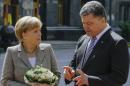 Merkel looks on as Poroshenko gestures in Kiev