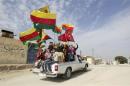 File photo shows people waving red, green and yellow Kurdish flags in the back of a truck as they celebrate what they said was the liberation of villages from Islamist rebels near the city of Ras al-Ain