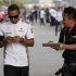 A fan asks McLaren Formula One driver Hamilton for an autograph as he walks in the paddock after the second practice session of the Japanese F1 Grand Prix at the Suzuka circuit