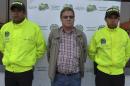 This photo released by Colombia's National Police shows American citizen Martin Stendal flanked by police officers at a police station in Bogota, Colombia, Thursday, Feb. 19, 2015. Police Col. Flavio Meza said that Stendal, a 59-year old native of Minnesota, surrendered Wednesday night to face an arrest warrant charging him with supporting terrorism and collaborating with the Revolutionary Armed Forces of Colombia rebel movement. Stendal says in a video posted online that he had been set up and that his trips into rebel territory to distribute Bibles and radios were only for ministering. (AP Photo/Colombia's National Police)