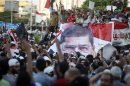 Supporters of ousted Egyptian President Mohamed Mursi chant slogans while carrying a big banner of Mursi in front of the Republican Guard headquarters as they camp for the third day in Cairo