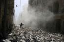 A man walks on the rubble of damaged buildings after an airstrike on the rebel held al-Qaterji neighbourhood of Aleppo