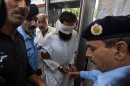 Pakistani police officers escort blindfolded Muslim cleric Khalid Chishti to appear in court in Islamabad, Pakistan, Sunday, Sept. 2, 2012. In the latest twist in a religiously charged case that has focused attention on the country's harsh blasphemy laws, Pakistani police arrested Chishti who they say planted evidence in the case of a Christian girl accused of blasphemy. (AP Photo/Anjum Naveed)